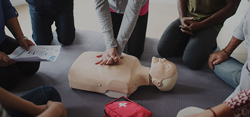 First Aid course participant practicing CPR on training manikin during professional First Aid courses in Newstead QLD